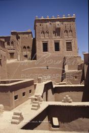 Image du Maroc Professionnelle de  La Kasbah de Taourirt fut édifiée au 17ème siècle par la tribu des Glaoui, située sur une colline au centre urbain de la ville d'Ouarzazate, cette remarquable ancienne bâtisse en pisé parfaitement conservée est l'une des plus belles constructions architecturales de la ville. La Kasbah qui ressemble à un grand château de sable incrusté dans le désert, fait partie du circuit touristique, elle a été classé Patrimoine Mondiale de l’Unesco. Ce véritable joyau de Ouarzazate permet au visiteur de découvrir l’intérieur d’une ksar où résident souvent la population berbères du sud du Maroc. Photo datant du Samedi 23 Août 1997. (Photo / Abdeljalil Bounhar)